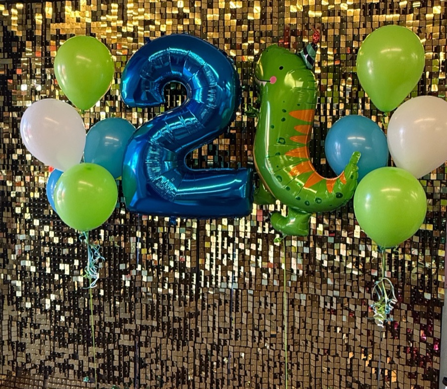 Blue foil number balloons with greenery on a gold sequin backdrop by AZ Party Mart