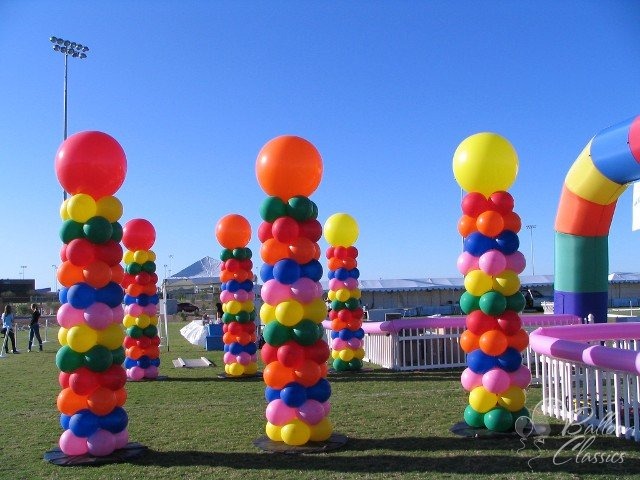 Multicolour rainbow balloon columns outdoors by AZ Party Mart