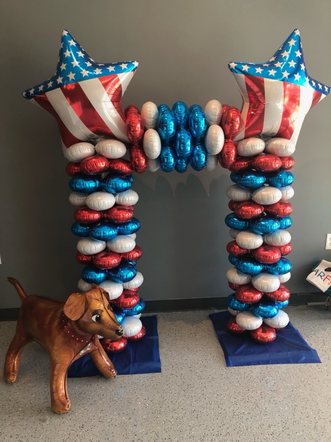 Patriotic star balloon columns with a balloon dog figure by AZ Party Mart