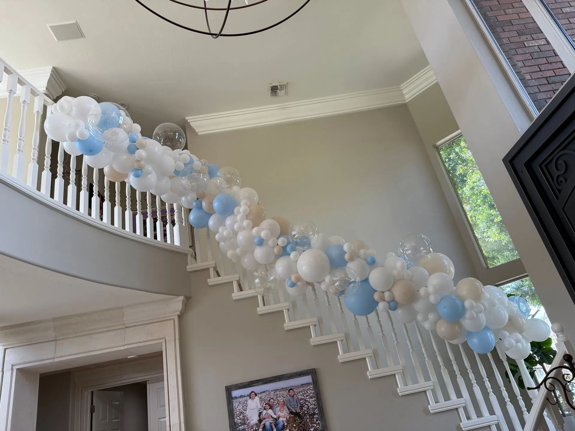Blue and white organic balloon garland on a grand curved staircase